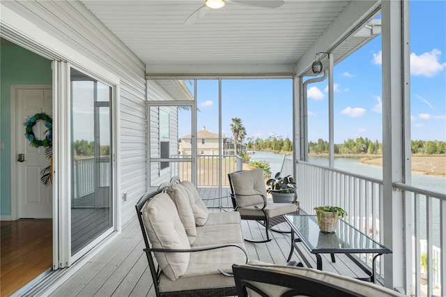 sunroom featuring a water view and ceiling fan