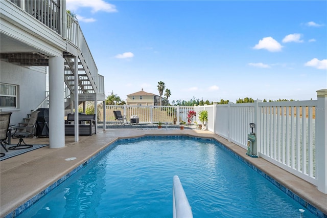 view of pool with stairs, fence, a fenced in pool, and a patio