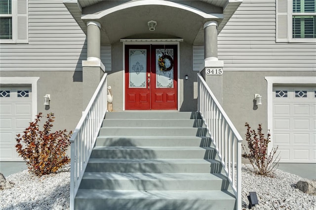 doorway to property featuring a garage and stucco siding