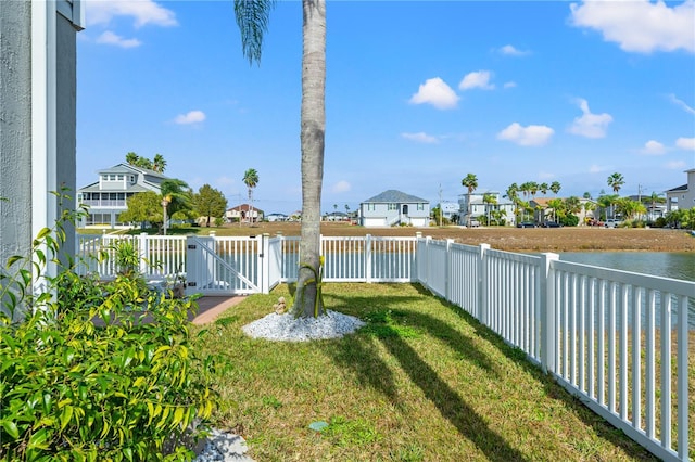 view of yard featuring a residential view, a fenced backyard, and a gate