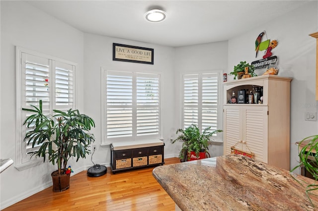 dining space with baseboards, a healthy amount of sunlight, and light wood finished floors