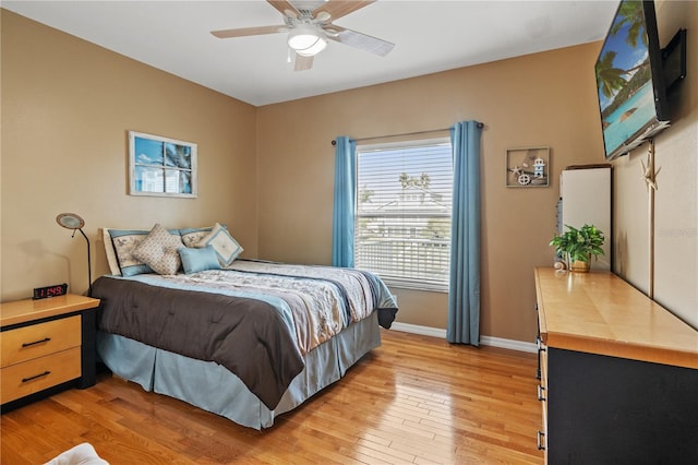 bedroom with baseboards, a ceiling fan, and light wood finished floors