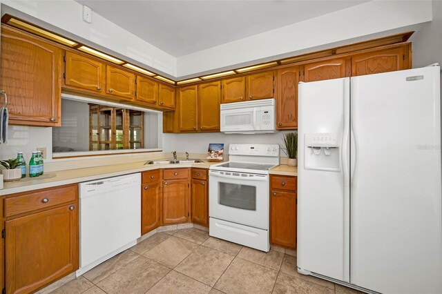 2446 Bentley Dr, Palm Harbor, FL 34684 - kitchen with light countertops, a sink, brown cabinets, and white appliances