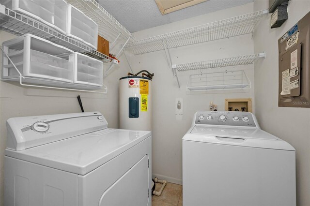 2446 Bentley Dr, Palm Harbor, FL 34684 - washroom featuring baseboards, laundry area, water heater, washer and clothes dryer, and light tile patterned floors