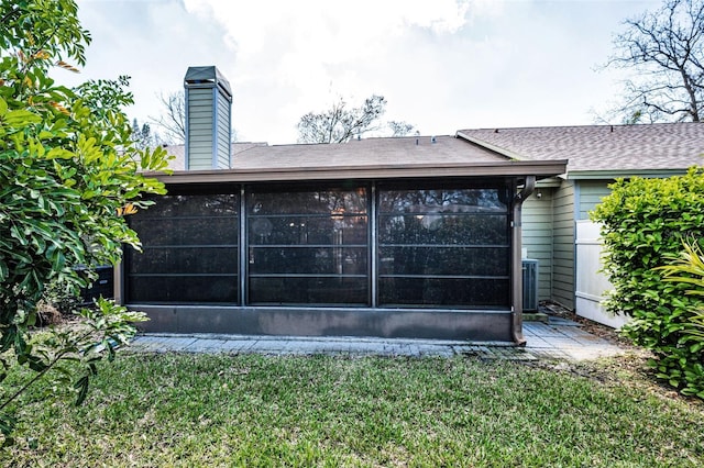 2446 Bentley Dr, Palm Harbor, FL 34684 - back of property with a lawn, a sunroom, and a shingled roof