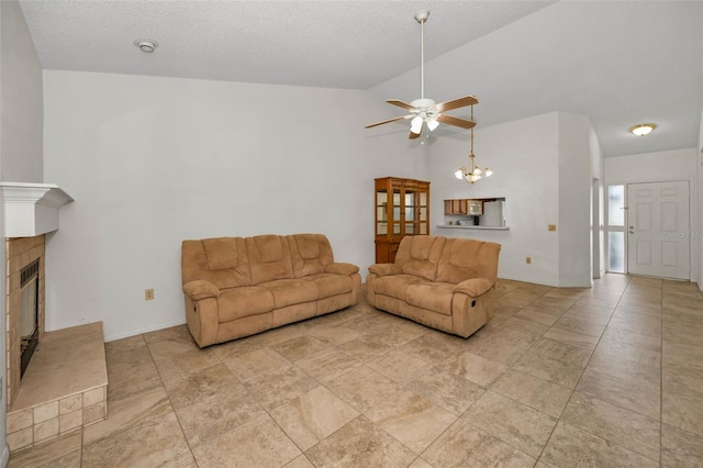 2446 Bentley Dr, Palm Harbor, FL 34684 - living room featuring ceiling fan with notable chandelier, lofted ceiling, a glass covered fireplace, and a textured ceiling