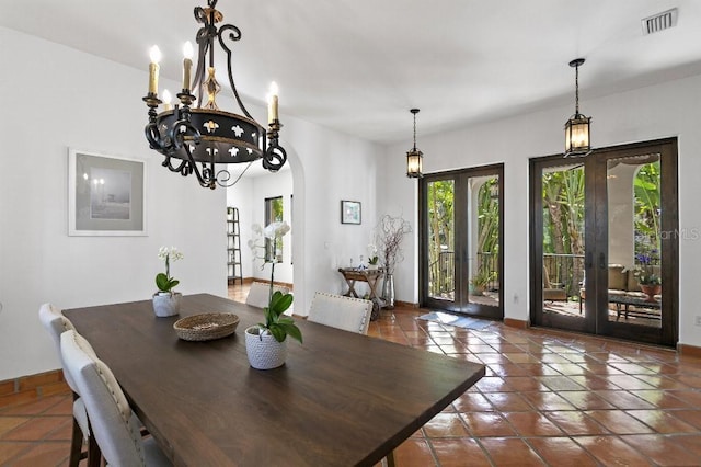 dining area featuring arched walkways, french doors, visible vents, and baseboards