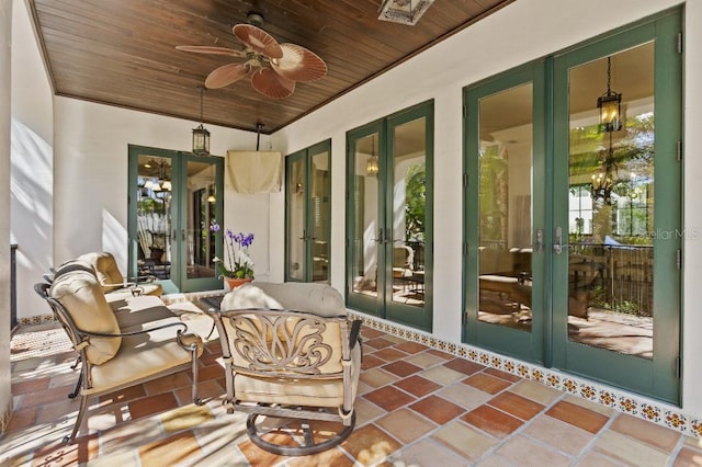 sunroom featuring wood ceiling, a ceiling fan, and french doors