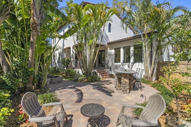 view of patio / terrace with a fire pit and fence