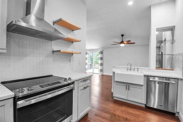 7 Georgia Ave, Crystal Beach, FL 34681 - kitchen featuring a ceiling fan, a sink, wall chimney range hood, stainless steel appliances, and light countertops