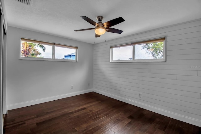 7 Georgia Ave, Crystal Beach, FL 34681 - unfurnished room featuring baseboards, plenty of natural light, ceiling fan, and dark wood-style flooring