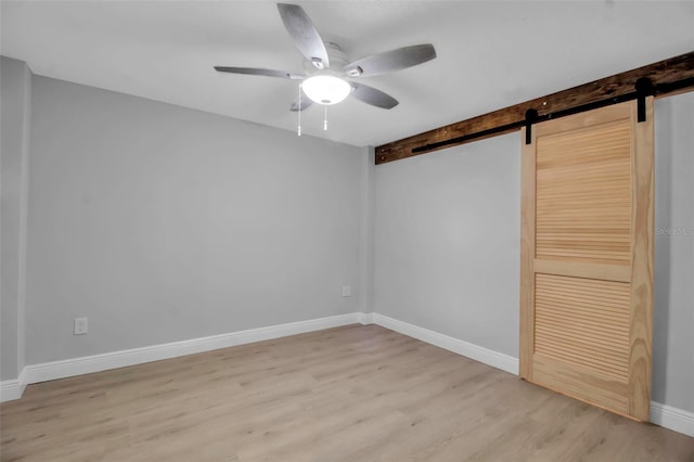 7 Georgia Ave, Crystal Beach, FL 34681 - interior space with light wood-style flooring, baseboards, a barn door, and a ceiling fan