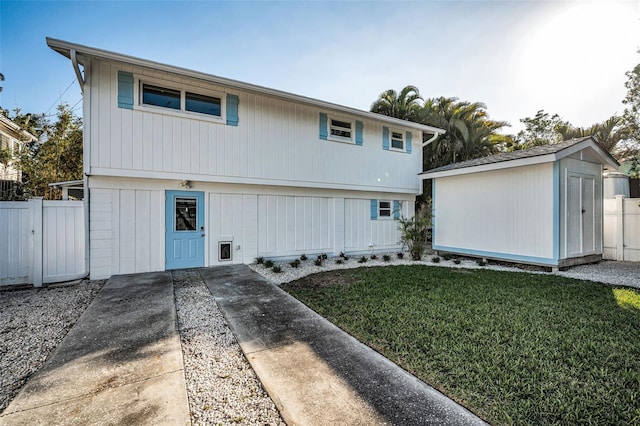 7 Georgia Ave, Crystal Beach, FL 34681 - back of house featuring a storage unit, a yard, an outdoor structure, and fence