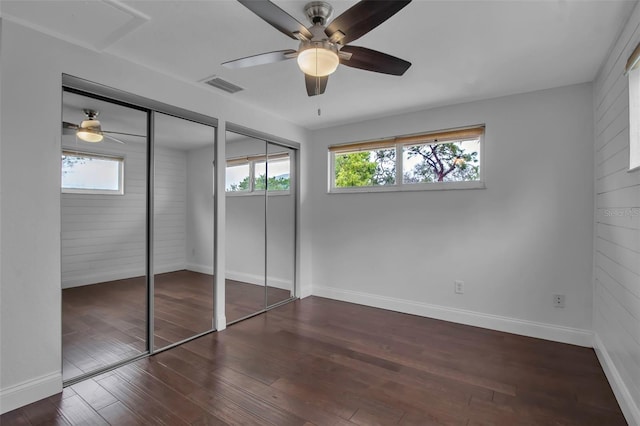 7 Georgia Ave, Crystal Beach, FL 34681 - unfurnished bedroom featuring visible vents, multiple windows, two closets, and wood finished floors