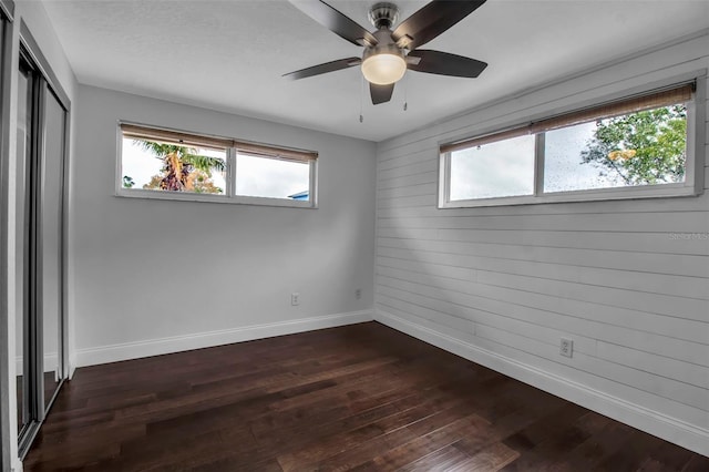 7 Georgia Ave, Crystal Beach, FL 34681 - unfurnished bedroom featuring dark wood finished floors, baseboards, a closet, and ceiling fan