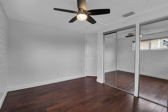 7 Georgia Ave, Crystal Beach, FL 34681 - unfurnished bedroom with wooden walls, wood finished floors, baseboards, visible vents, and ceiling fan