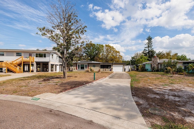 view of front of home with a carport, concrete driveway, and an attached garage