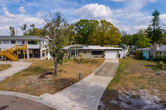 view of front of property featuring a garage, concrete driveway, and a carport