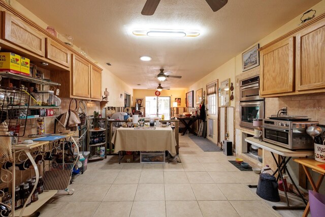 kitchen with decorative backsplash, ceiling fan, a textured ceiling, double oven, and light tile patterned flooring