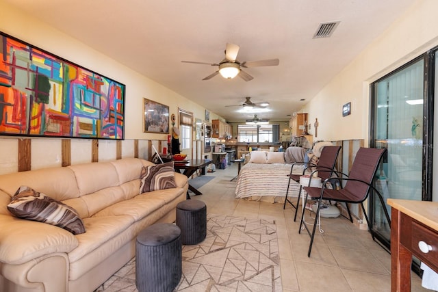 living room featuring light tile patterned floors, visible vents, and a ceiling fan