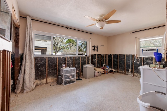 miscellaneous room with a textured ceiling, plenty of natural light, cooling unit, and a ceiling fan