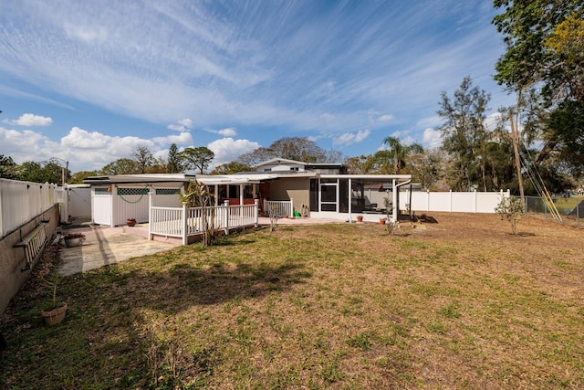 back of property featuring a sunroom, a fenced backyard, a patio area, and a yard