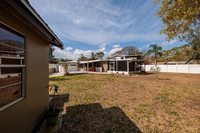 view of yard featuring a fenced backyard and a sunroom