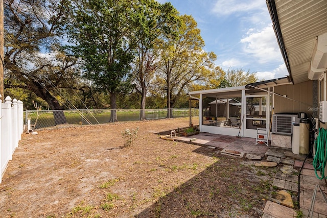 view of yard featuring cooling unit, a fenced backyard, and a sunroom