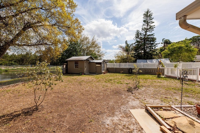 view of yard featuring a fenced backyard, an outdoor structure, and a storage unit