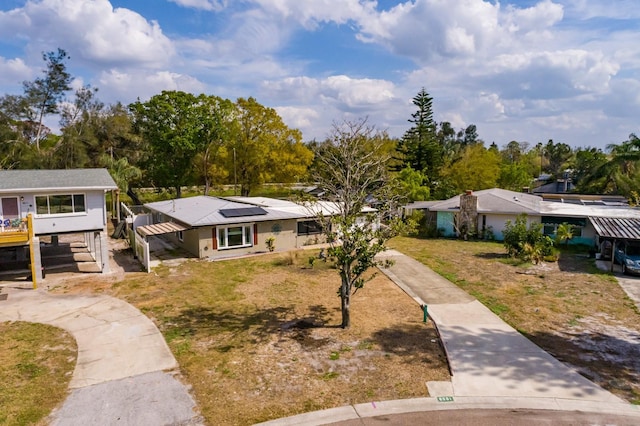 view of front of home with a front lawn and solar panels