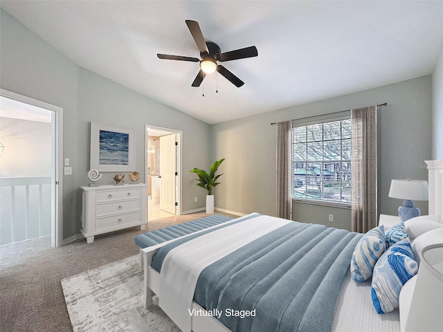 bedroom with a ceiling fan, carpet flooring, vaulted ceiling, ensuite bath, and baseboards