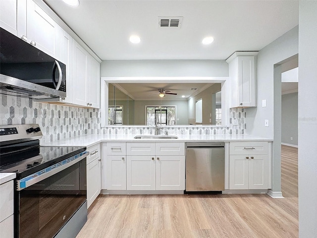 kitchen with light countertops, visible vents, light wood-style flooring, appliances with stainless steel finishes, and a sink