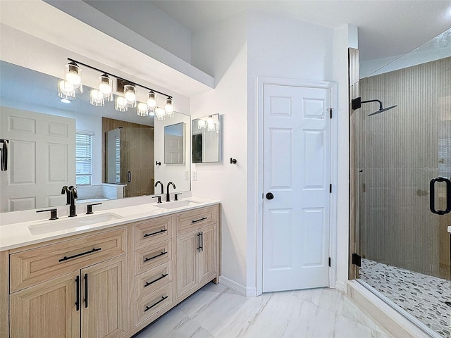 bathroom featuring marble finish floor, a sink, a shower stall, and baseboards