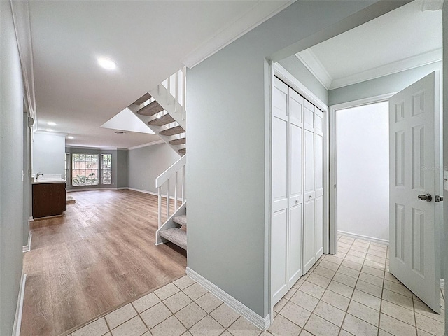 hallway featuring ornamental molding, stairway, and light tile patterned floors