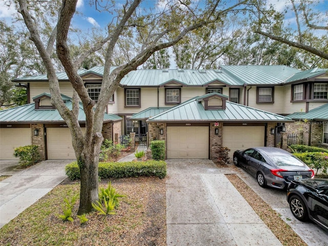 multi unit property featuring a standing seam roof, metal roof, and brick siding