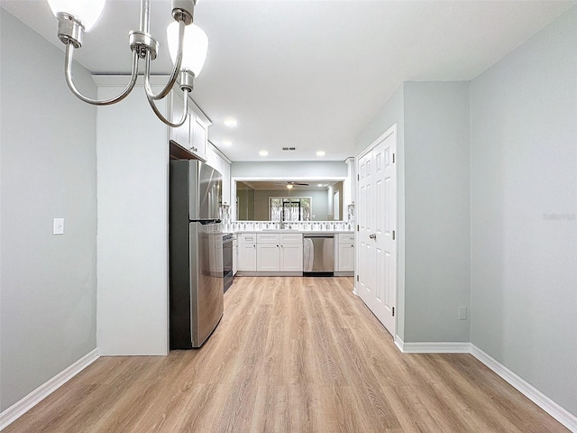 kitchen with stainless steel appliances, light countertops, and light wood-style floors