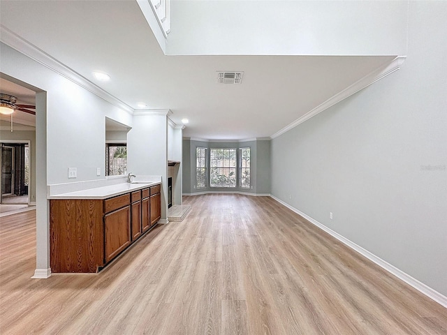 living room with a fireplace with raised hearth, ceiling fan, light wood-style flooring, visible vents, and baseboards