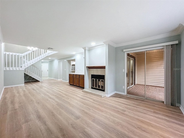 unfurnished living room with light wood-style floors, visible vents, a fireplace, and stairway