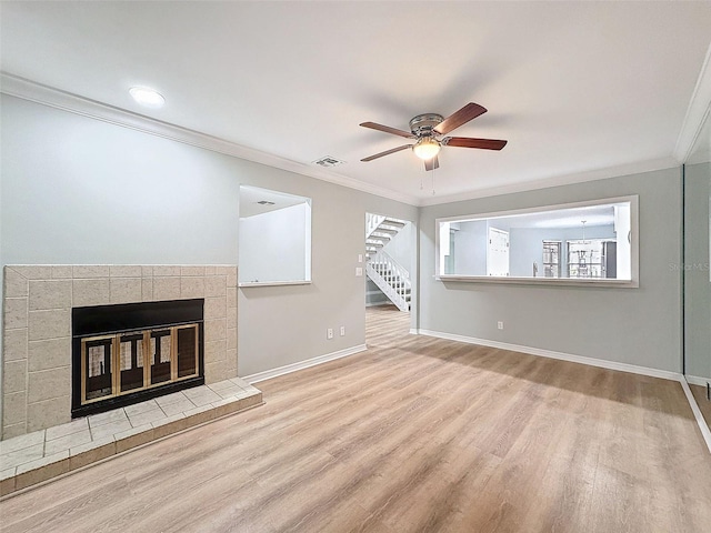 unfurnished living room featuring a fireplace, wood finished floors, visible vents, baseboards, and crown molding