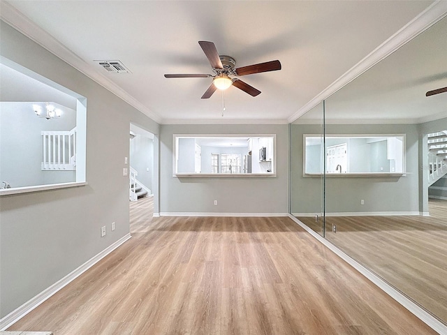 unfurnished living room featuring stairs, ornamental molding, wood finished floors, and visible vents