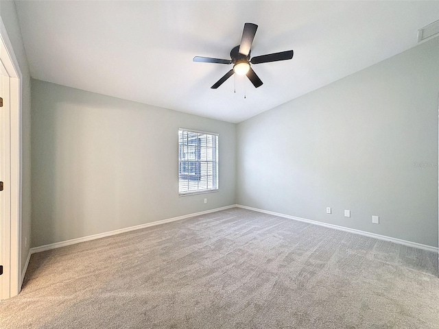 carpeted spare room with baseboards and a ceiling fan