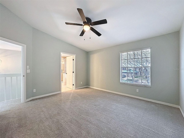 unfurnished bedroom featuring carpet floors, baseboards, vaulted ceiling, and connected bathroom