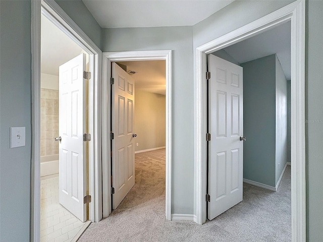 corridor with light carpet and baseboards