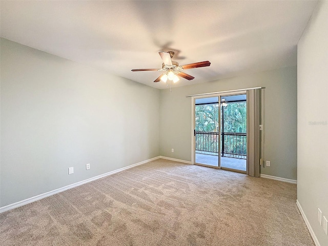 carpeted empty room featuring baseboards and a ceiling fan