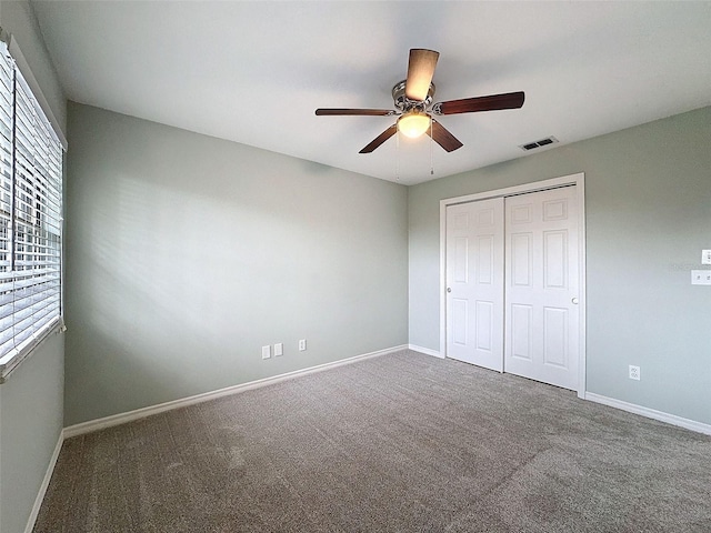 unfurnished bedroom with a ceiling fan, visible vents, baseboards, a closet, and carpet