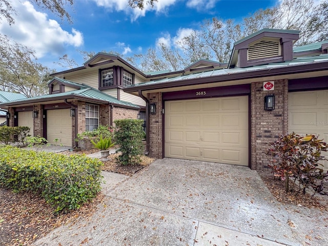 view of front of home with driveway, brick siding, and an attached garage