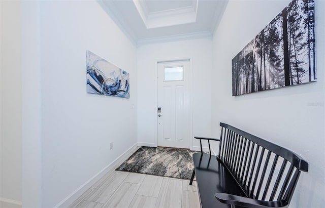 entryway featuring baseboards, a tray ceiling, and crown molding