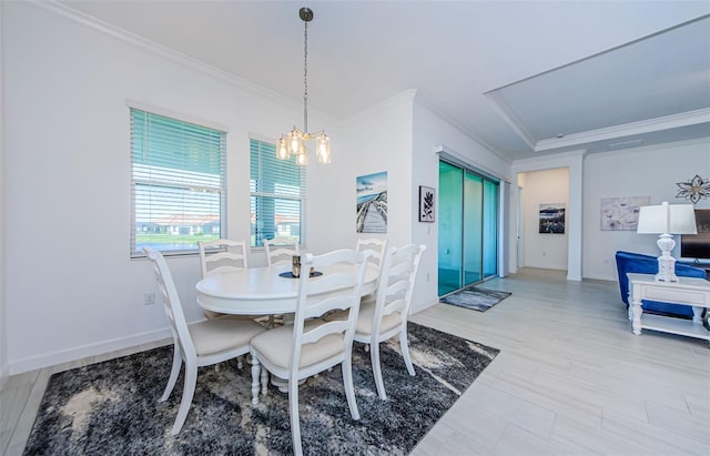 dining space with crown molding, baseboards, and an inviting chandelier