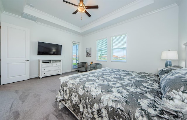 carpeted bedroom with ceiling fan, visible vents, baseboards, ornamental molding, and a tray ceiling