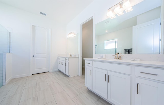 full bath with two vanities, visible vents, a sink, baseboards, and walk in shower